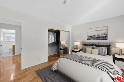 a bedroom with a bed and wooden floor