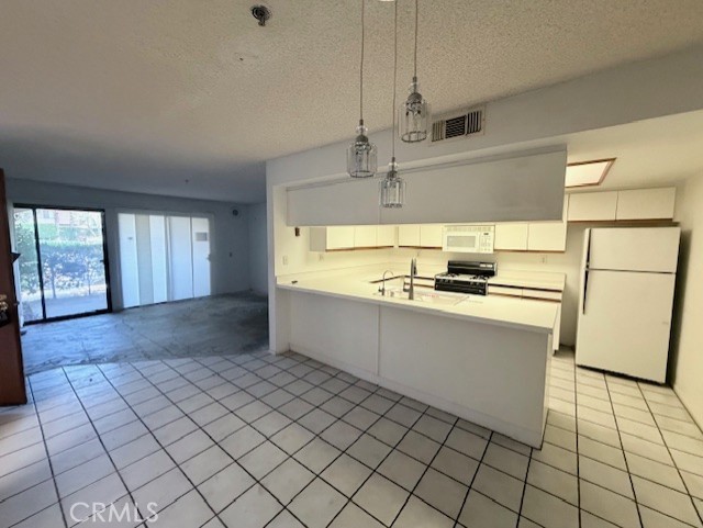 200 East Racquet Club Road, Unit 35 Palm Springs, CA 92262 - Photo 2 of 8 a kitchen with granite countertop a refrigerator and a stove top oven