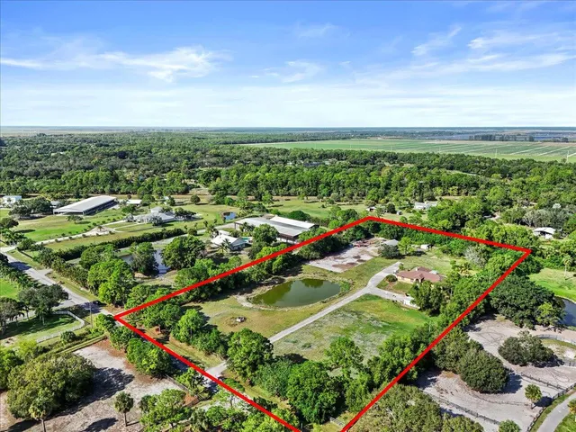 an aerial view of residential houses with outdoor space and trees