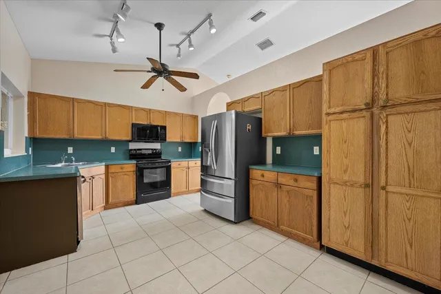 a large kitchen with stainless steel appliances a refrigerator and a stove top oven