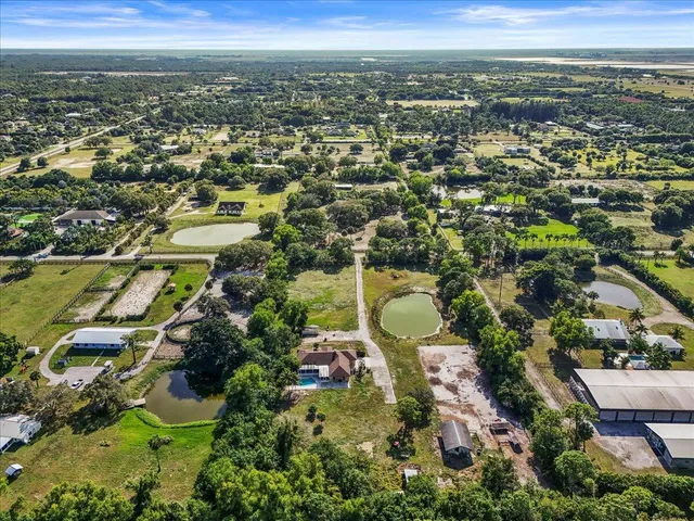 an aerial view of residential houses with outdoor space and trees
