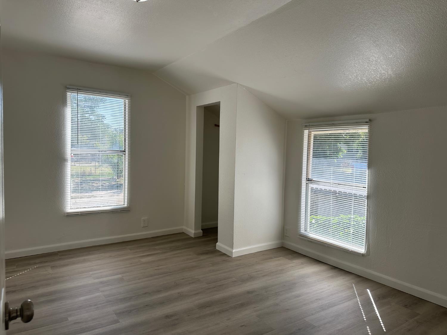 809 Washington Avenue Madera, CA 93638 - Photo 8 of 20 a view of an empty room with wooden floor and a window