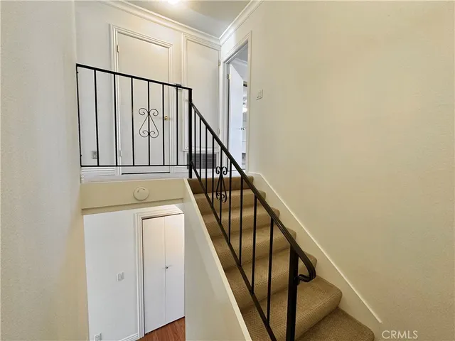 a view of staircase with wooden floor and white walls