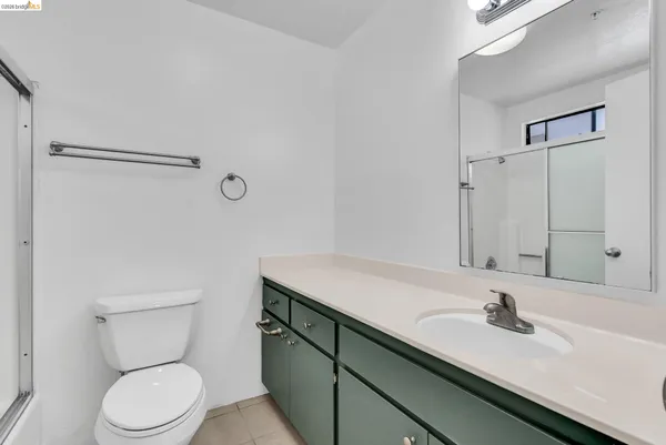 a bathroom with a granite countertop sink a toilet and a mirror