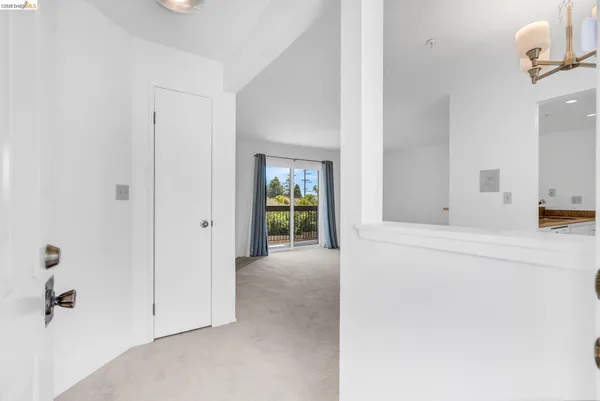 a view of a hallway with wooden floor and a bathroom