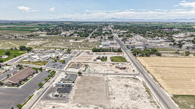 84 White Sage Avenue, Unit 2 Delta, UT 84624 - Photo 1 of 18 Expansive aerial capturing a commercial development, agricultural fields, and a residential area