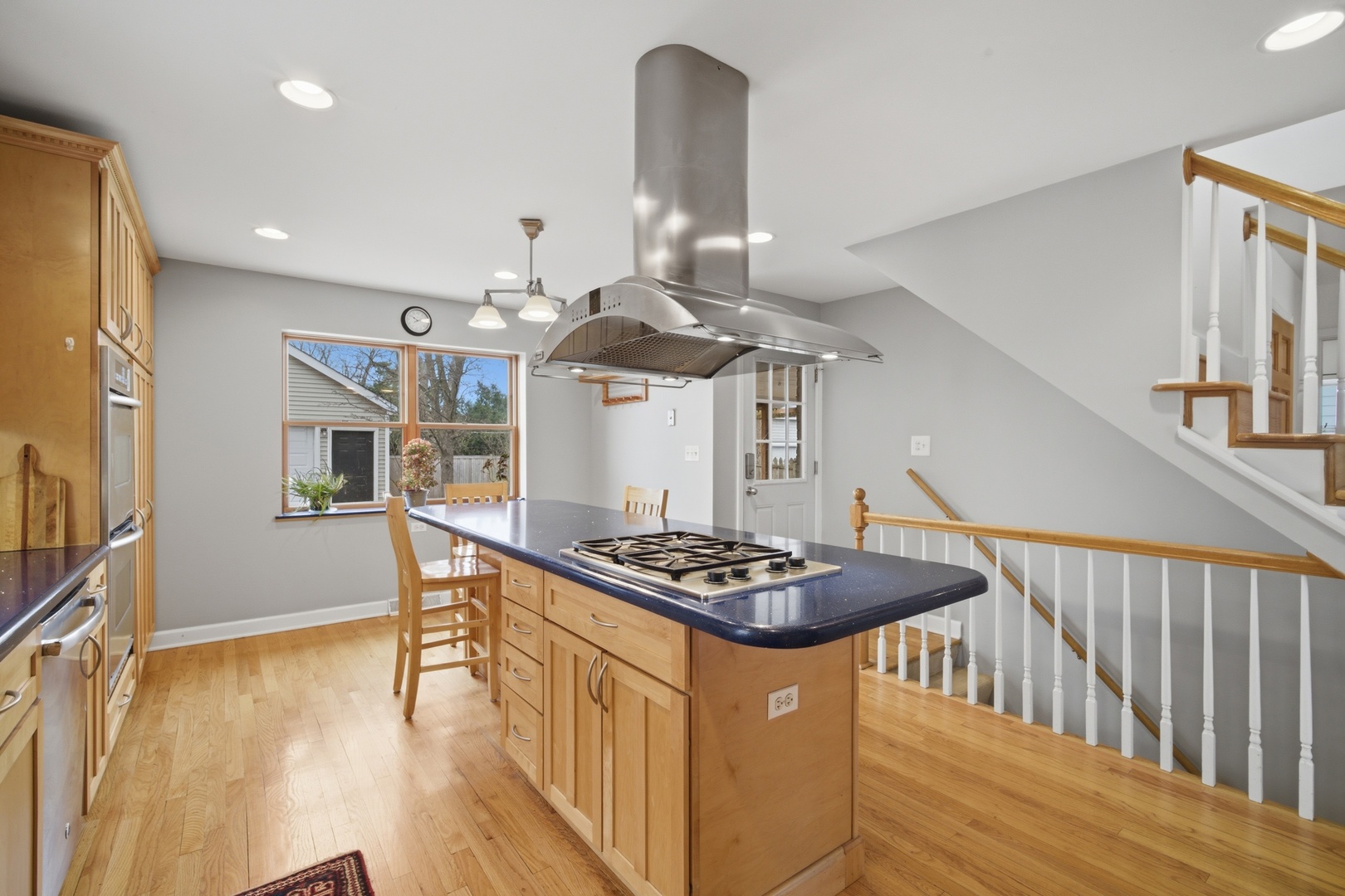 1917 Kiest Avenue Northbrook, IL 60062 - Photo 6 of 27 a kitchen with stainless steel appliances granite countertop a stove a sink dishwasher and a dining table with wooden floor