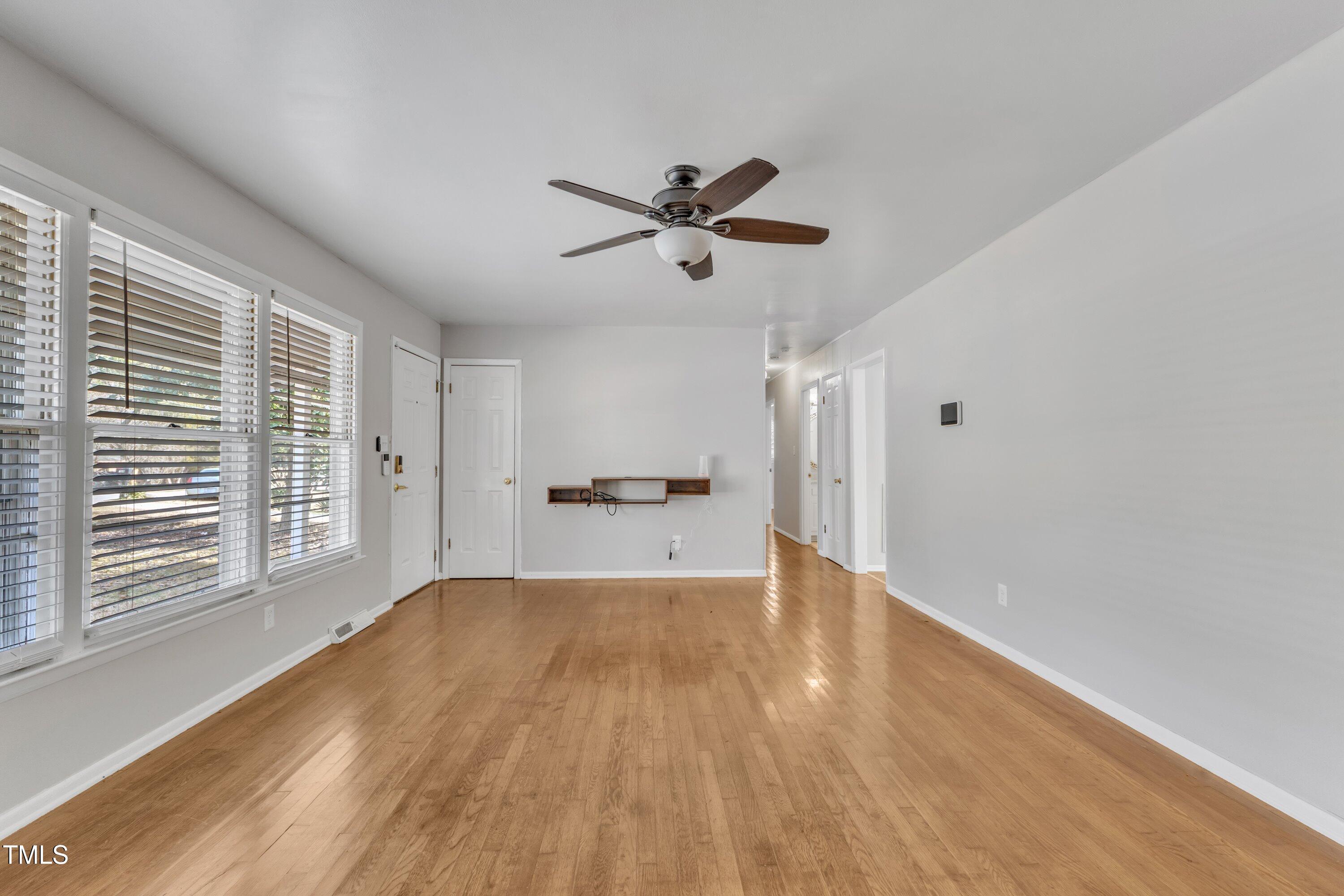 704 Sunnybrook Road Raleigh, NC 27610 - Photo 3 of 33 a view of a livingroom with a ceiling fan and wooden floor