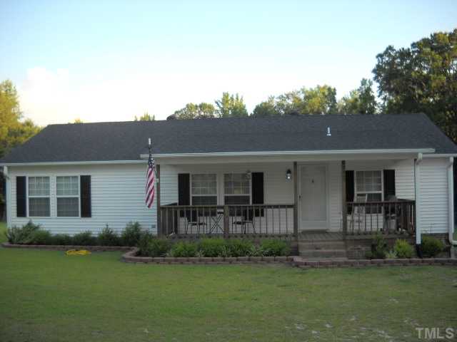 a view of a yard in front of a house with a large tree