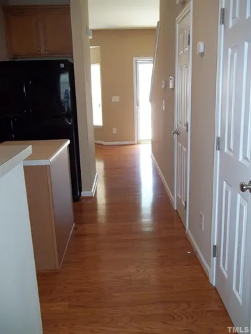 a view of a hallway with wooden floor and staircase