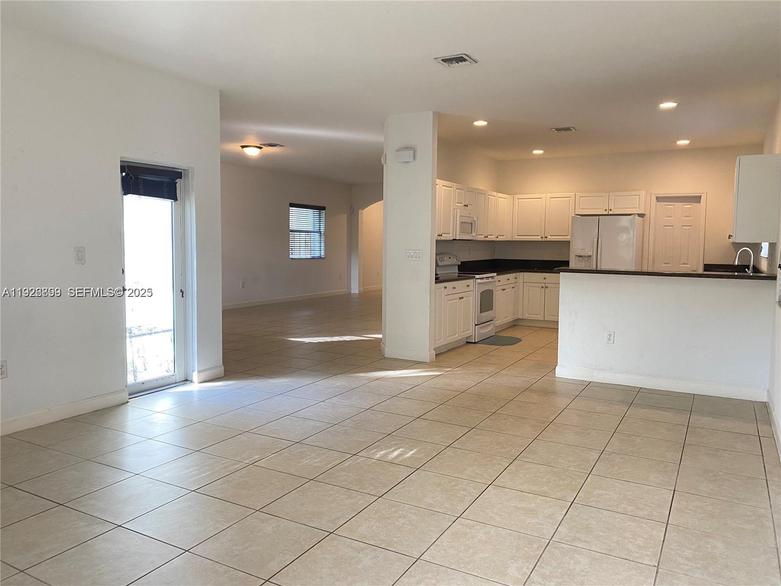 3616 Northeast 3rd Court Homestead, FL 33033 - Photo 3 of 11 a view of a kitchen with kitchen island granite countertop a refrigerator and a stove top oven