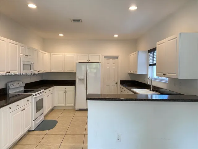 a kitchen with stainless steel appliances granite countertop a sink and cabinets