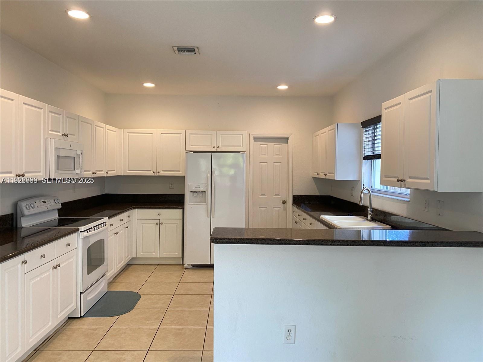 3616 Northeast 3rd Court Homestead, FL 33033 - Photo 4 of 11 a kitchen with stainless steel appliances granite countertop a sink and cabinets