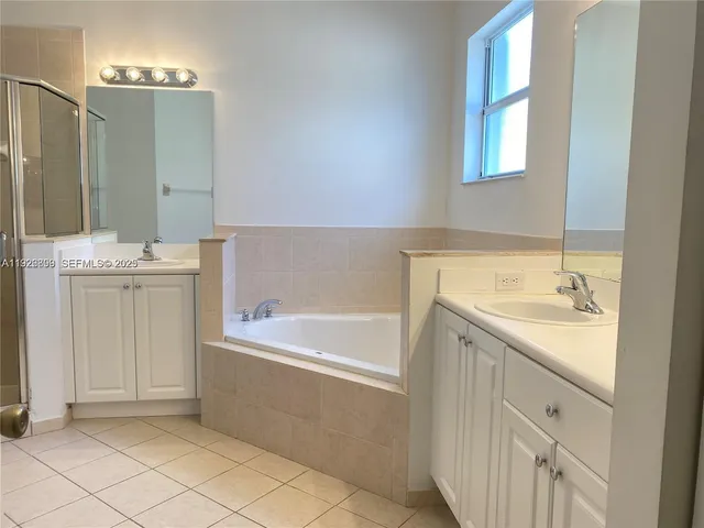 a bathroom with a tub sink and mirror