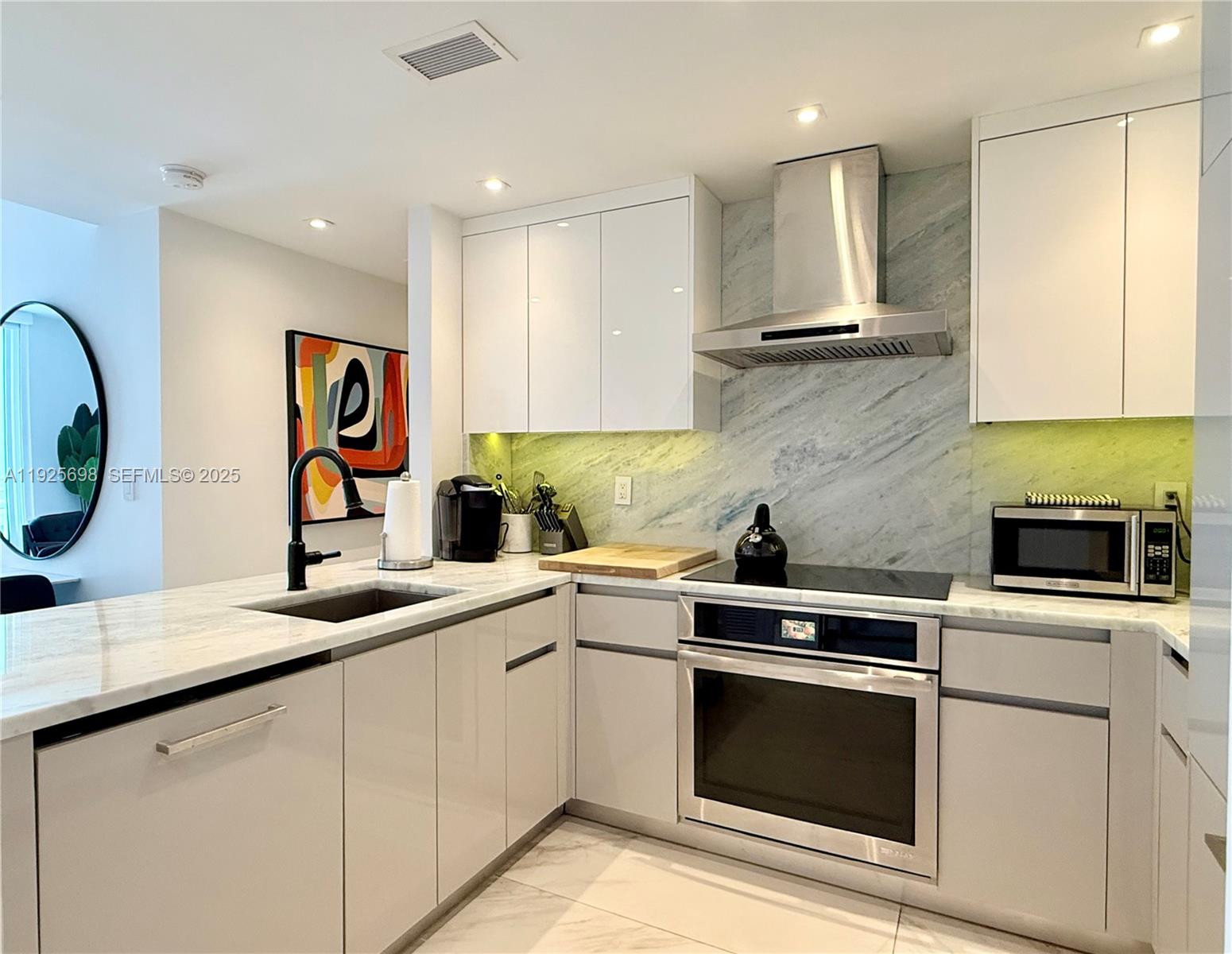 225 Collins Avenue, Unit 6J Miami Beach, FL 33139 - Photo 10 of 49 a kitchen with a sink stove and microwave