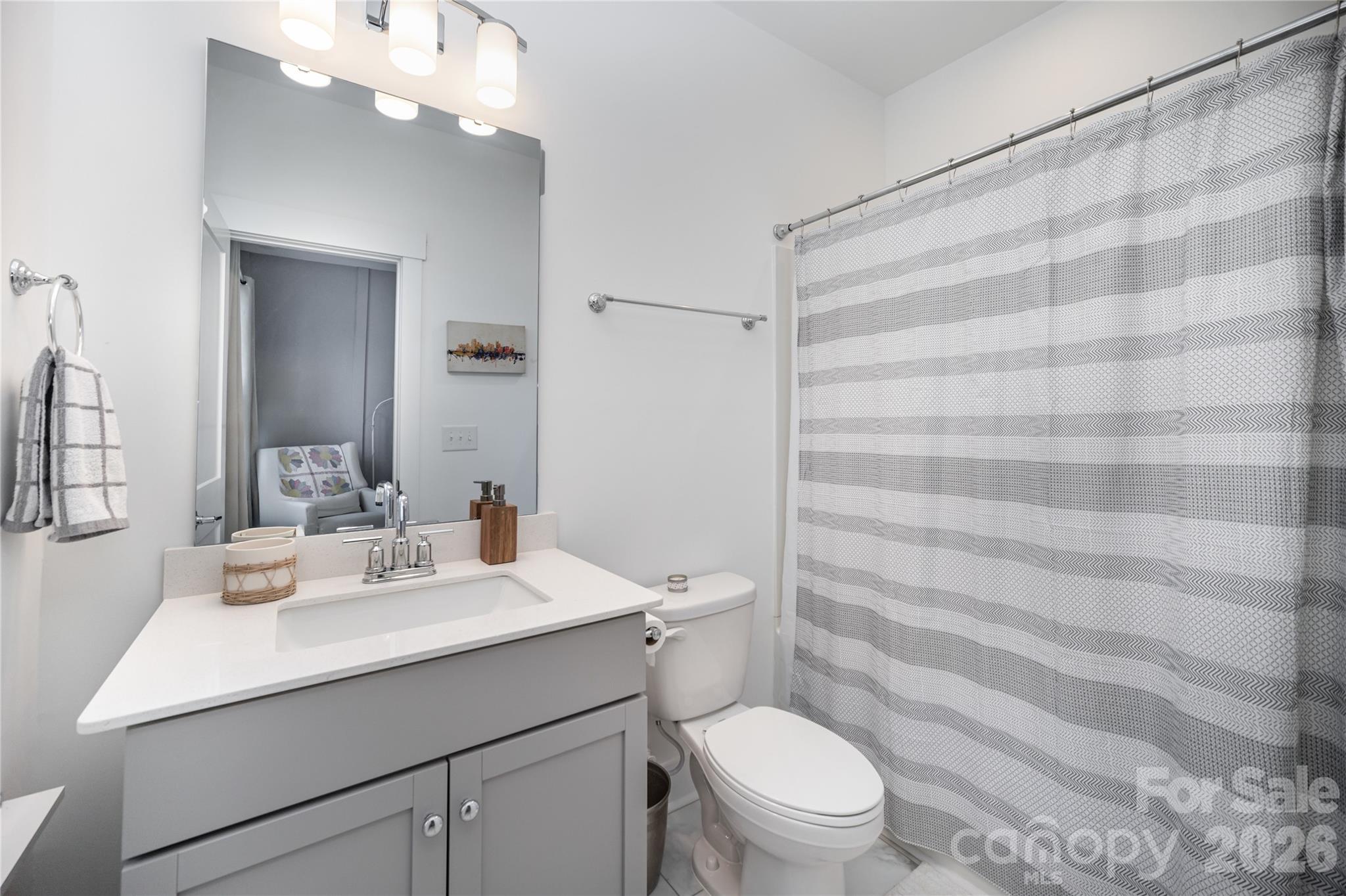 4004 Capital Ridge Charlotte, NC 28205 - Photo 22 of 30 a bathroom with a sink a toilet a mirror and shower curtain