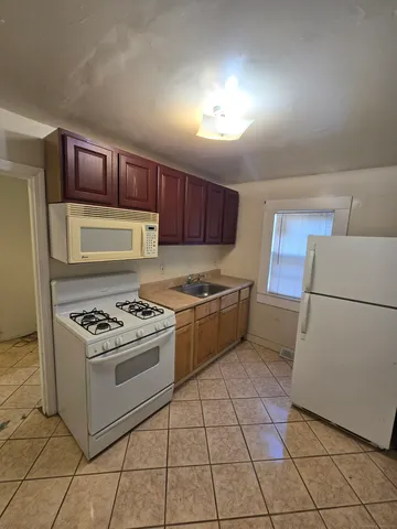 a kitchen with a stove a sink dishwasher and a refrigerator