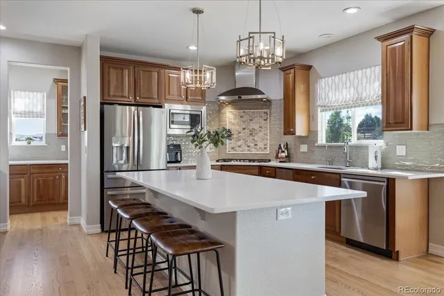 a kitchen with stainless steel appliances granite countertop a sink stove and refrigerator