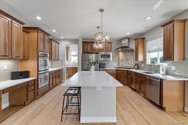 a large kitchen with stainless steel appliances kitchen island granite countertop a large kitchen island a stove a sink a refrigerator and a wooden cabinets