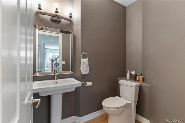 a bathroom with a sink a toilet and mirror