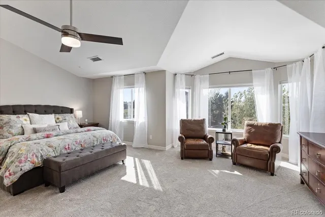 a bedroom with a bed couch and a large window