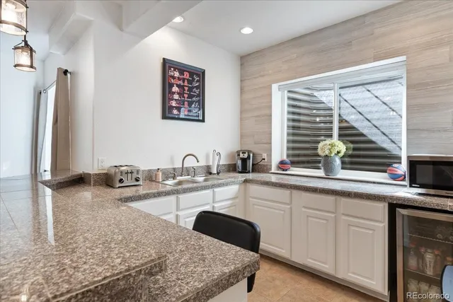 a living room with furniture a table and kitchen view
