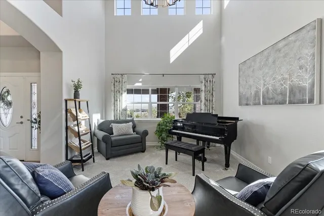 a living room with furniture and a piano