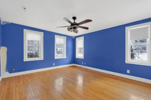 a view of an empty room with workspace and wooden floor