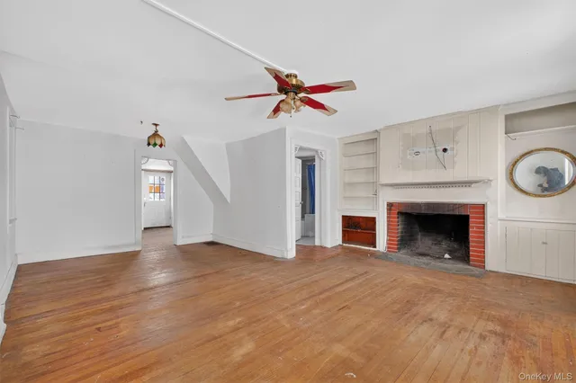 an empty room with windows and fireplace