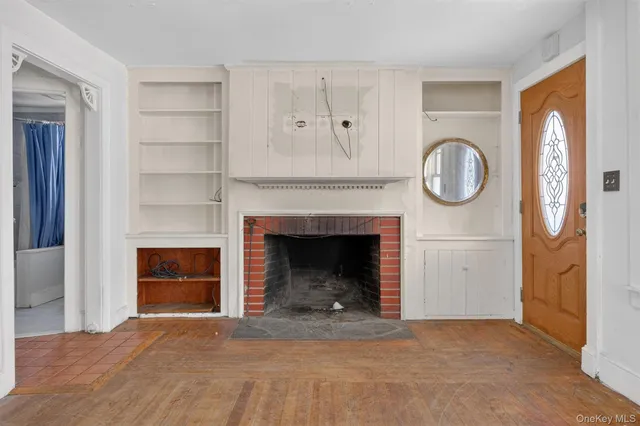 a view of an empty room with wooden floor and closet