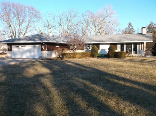 a view of a large house with a big yard and large tree