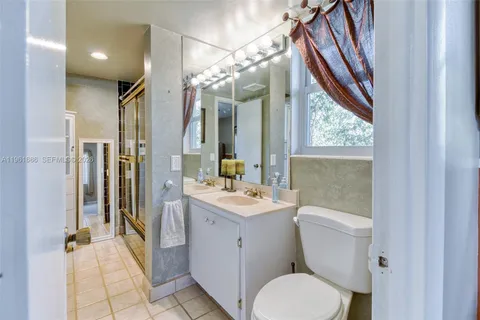 a bathroom with a sink a toilet a mirror and shower