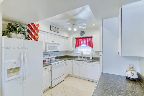 a kitchen with stainless steel appliances granite countertop a sink and dishwasher refrigerator a microwave