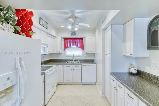 a kitchen with granite countertop a sink stainless steel appliances and cabinets