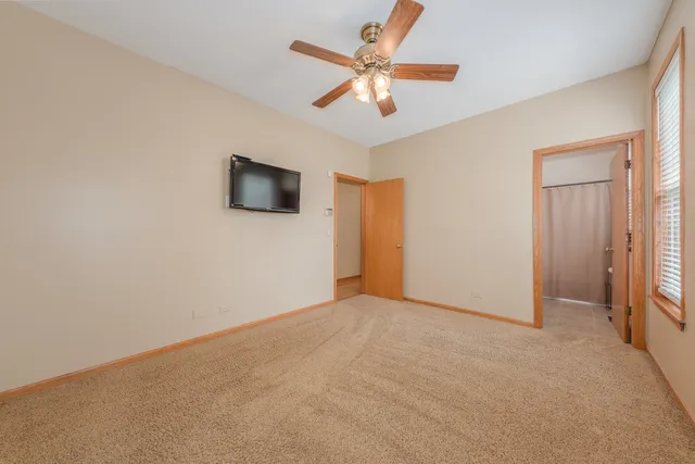 an empty room with closet and fan