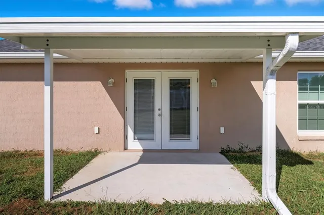 a view of a house with a yard and a large tree
