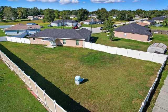 a view of a house with pool lawn chairs and a yard