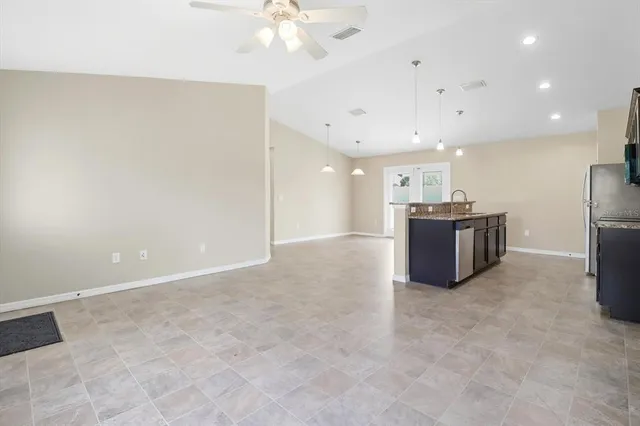 a view of kitchen with stainless steel appliances granite countertop refrigerator sink and stove