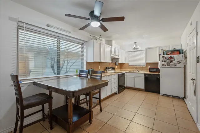 a kitchen with a stove a sink cabinets and a refrigerator