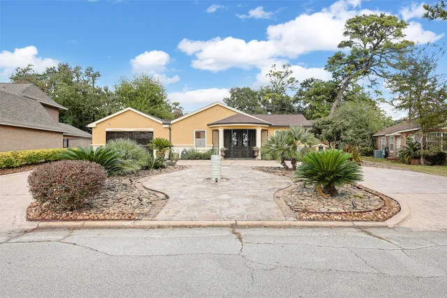 a front view of a house with a garden and yard