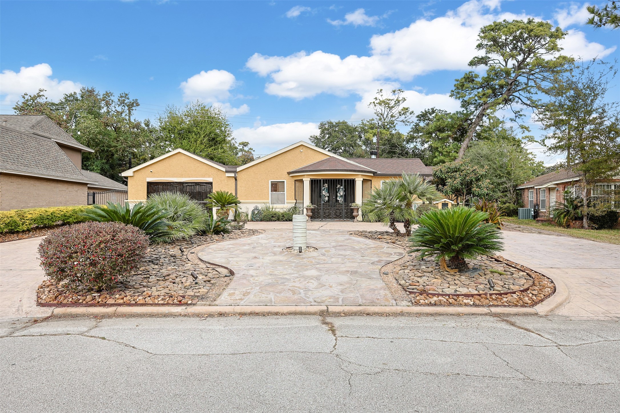 a front view of a house with a garden and yard