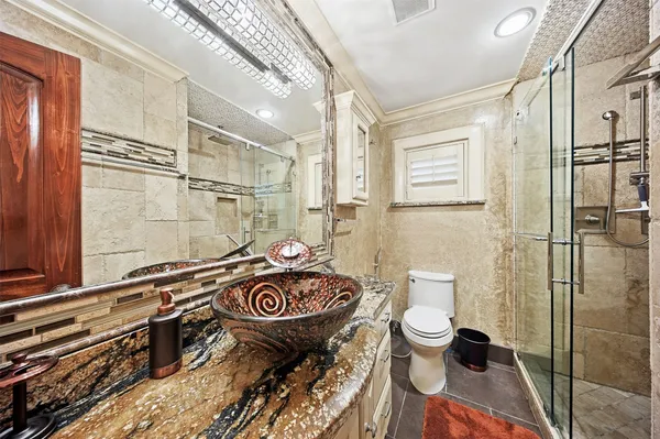 a bathroom with a sink a toilet and shower