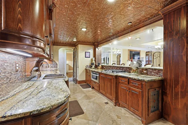 a large kitchen with granite countertop a sink and stove