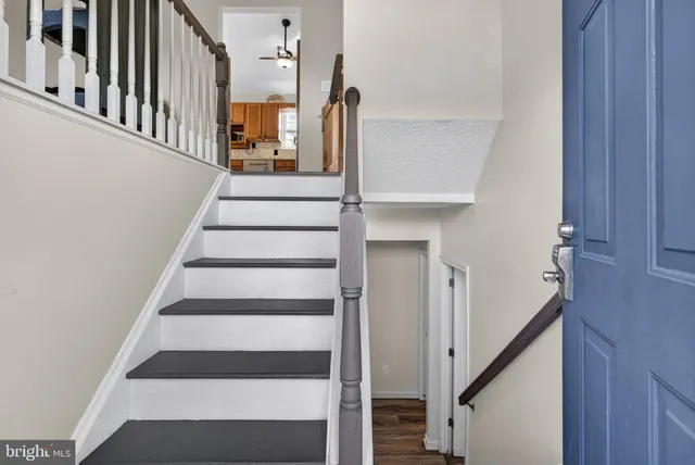 a view of staircase with railing and white walls