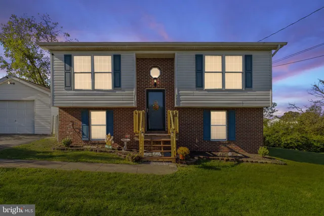 a front view of a house with a garden and trees