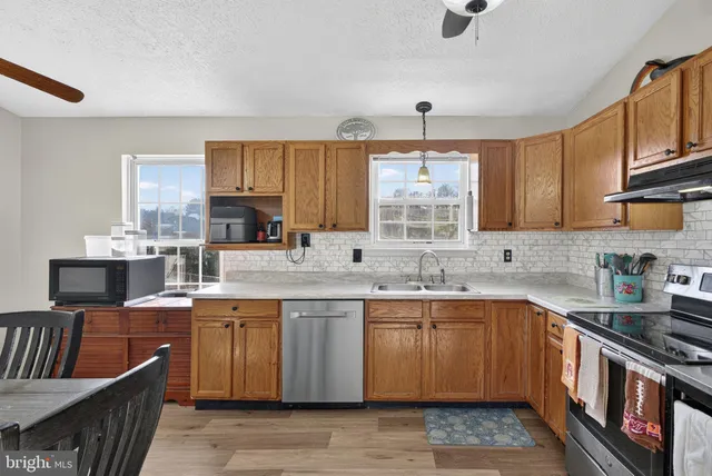 a kitchen with stainless steel appliances granite countertop a sink a refrigerator and cabinets