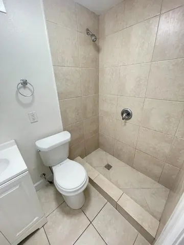 a white toilet sitting next to a bath tub and a shower