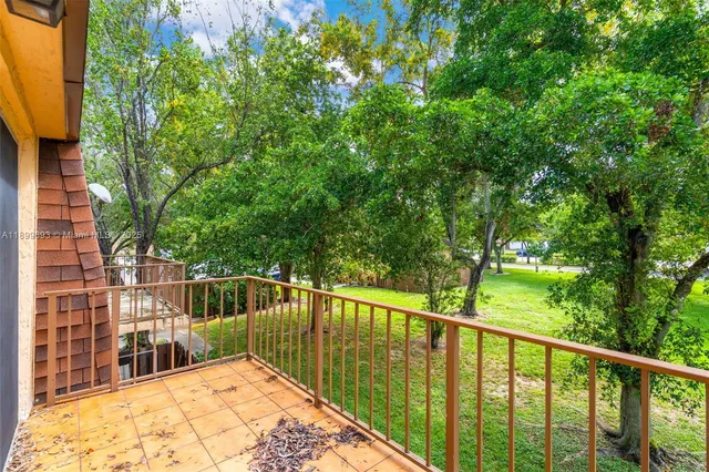 a view of a house with a small yard and a large tree