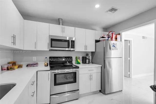 a kitchen with white cabinets and white appliances