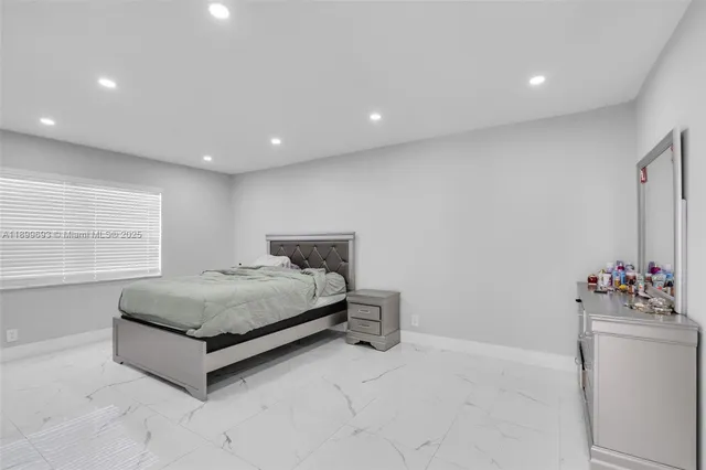 a large bedroom with a bed and a large mirror